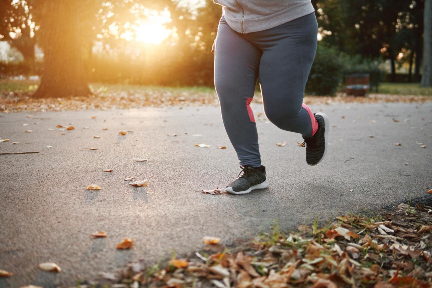 young female runner running in park, waist down