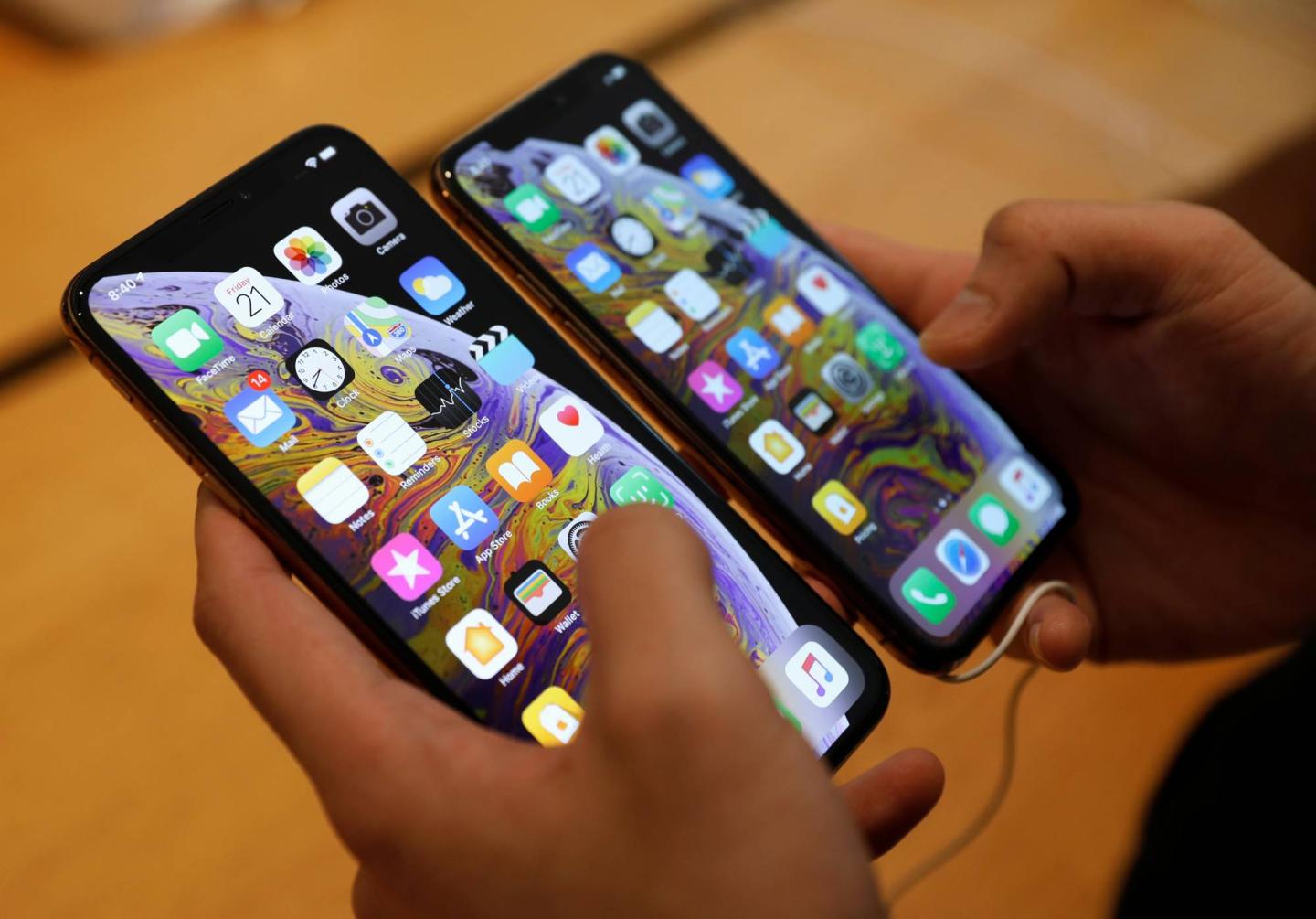 A customer compares the size of the new iPhone XS and iPhone XS Max at the Apple Store in Singapore