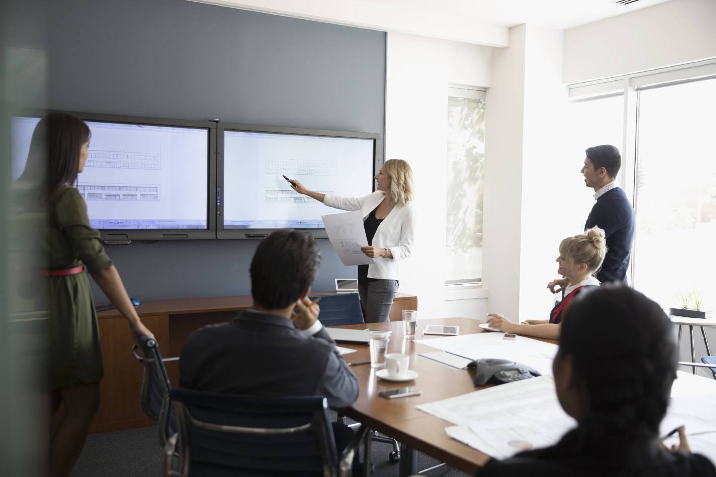 Businesswoman leading conference room meeting at television monitor