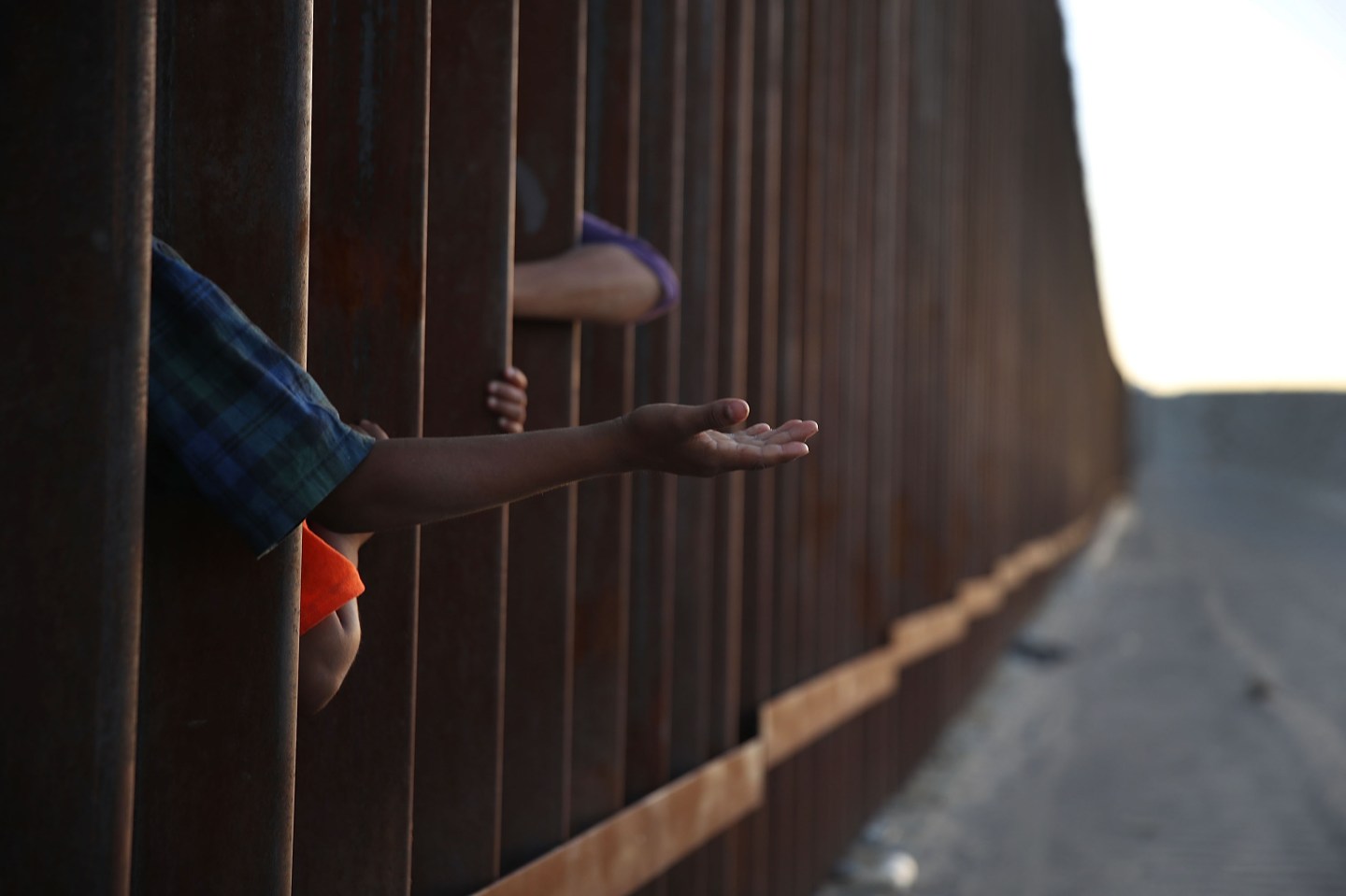 A child reaches through from the Mexican side of the U.S./Mexico border fence on June 24, 2018 in Sunland Park, New Mexico.