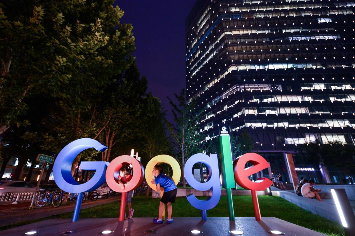 Children play around a sign of Alphabet Inc's Google outside its office in Beijing