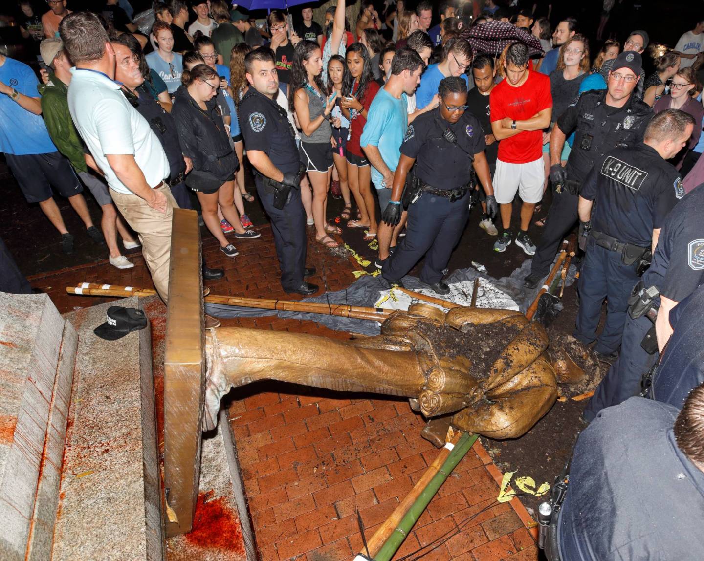 Police and protesters surround the toppled statue of a Confederate soldier nicknamed Silent Sam on the University of North Carolina campus after a demonstration for its removal in Chapel Hill
