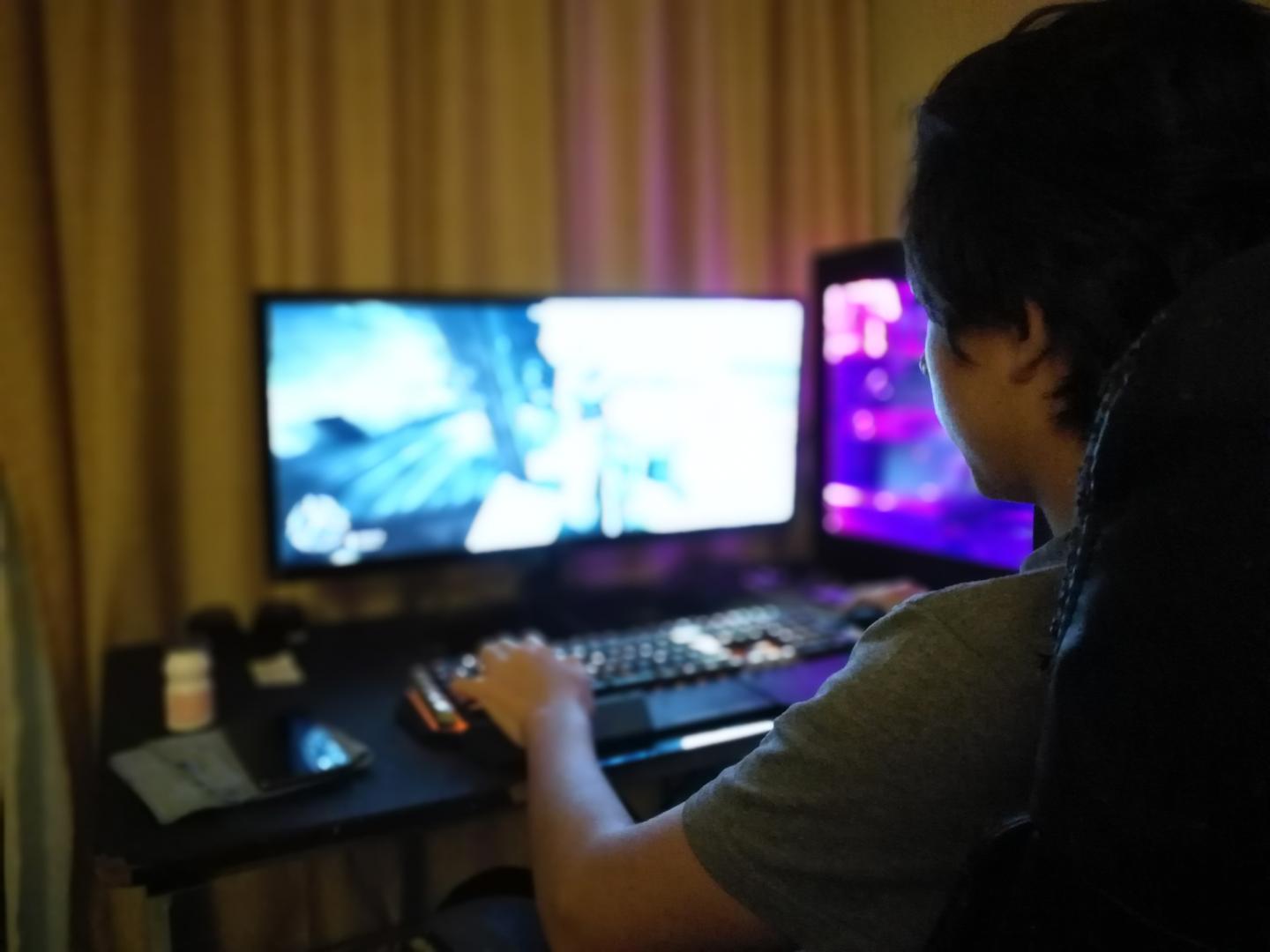Side View Of Boy Playing Game On Computer At Home