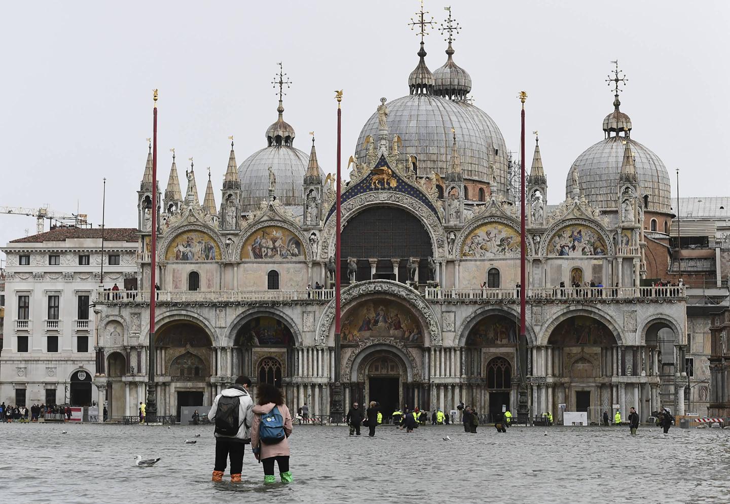 Tourists walk in Piazza San Marco on Oct. 29, 2018, as Venice is inundated by near-record flooding and ferocious storms.