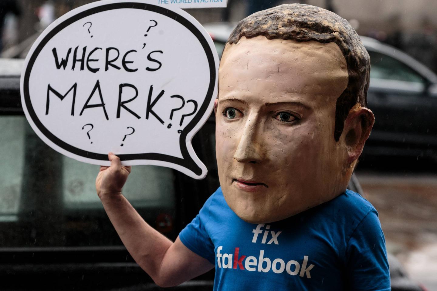 A protester wearing a model head of Facebook CEO Mark Zuckerberg poses for media on Nov. 27, 2018 in London.