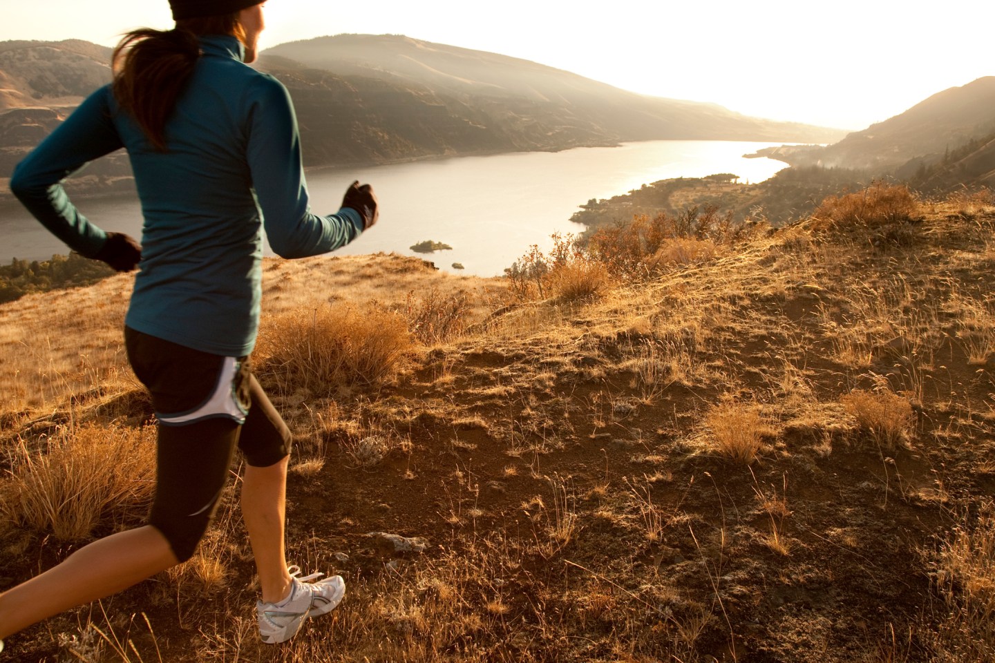 An athletic woman trail running.