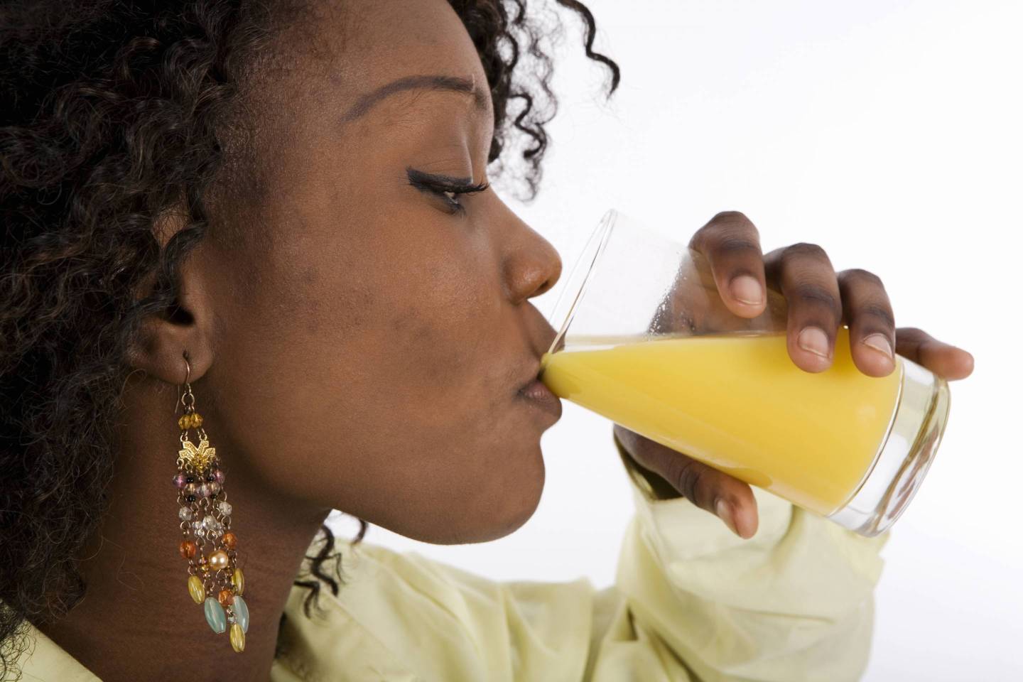 Profile of young woman drinking glass of orange juice