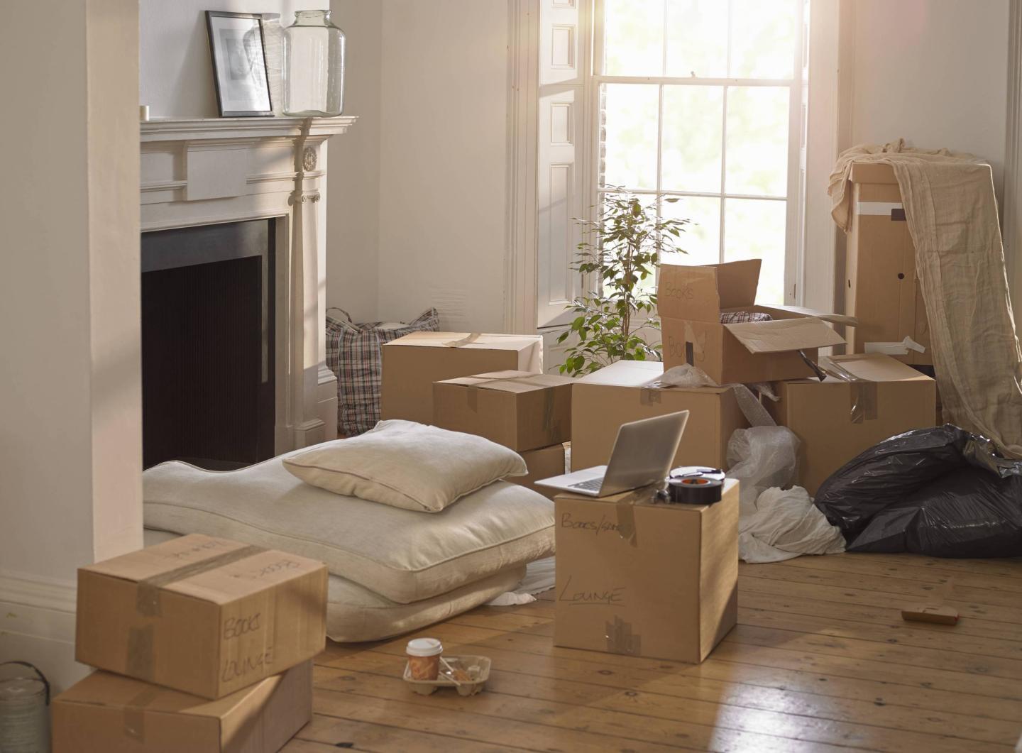 A room full of packing boxes and a laptop