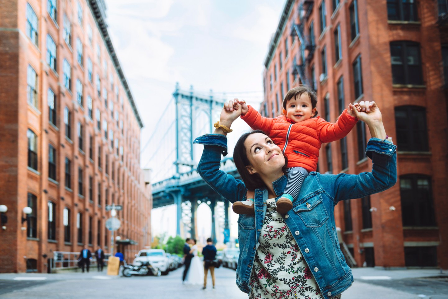 USA, New York, New York City, Mother and baby in Brooklyn with Manhattan Bridge in the background