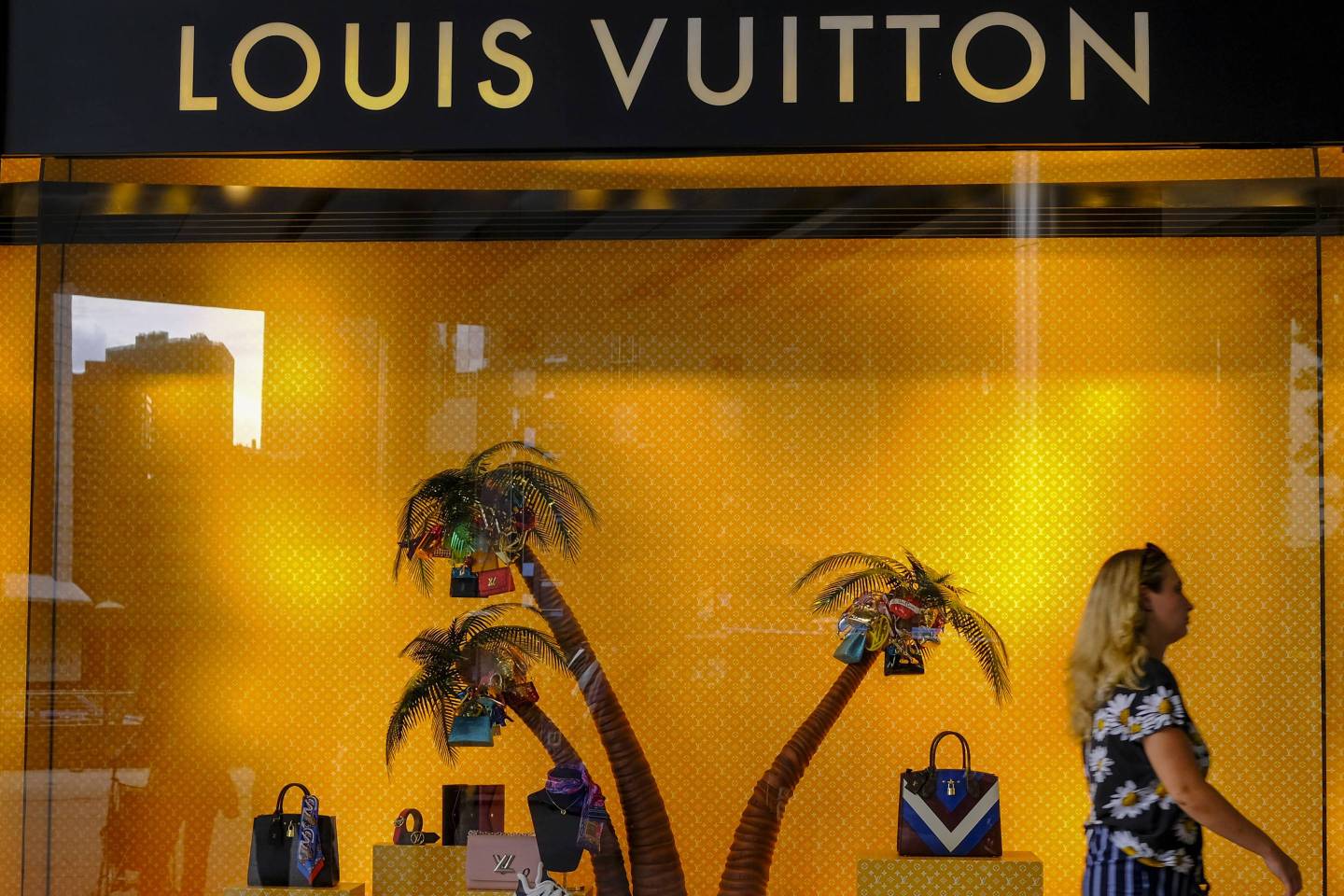 A lady seen passing by a Louis Vuitton boutique