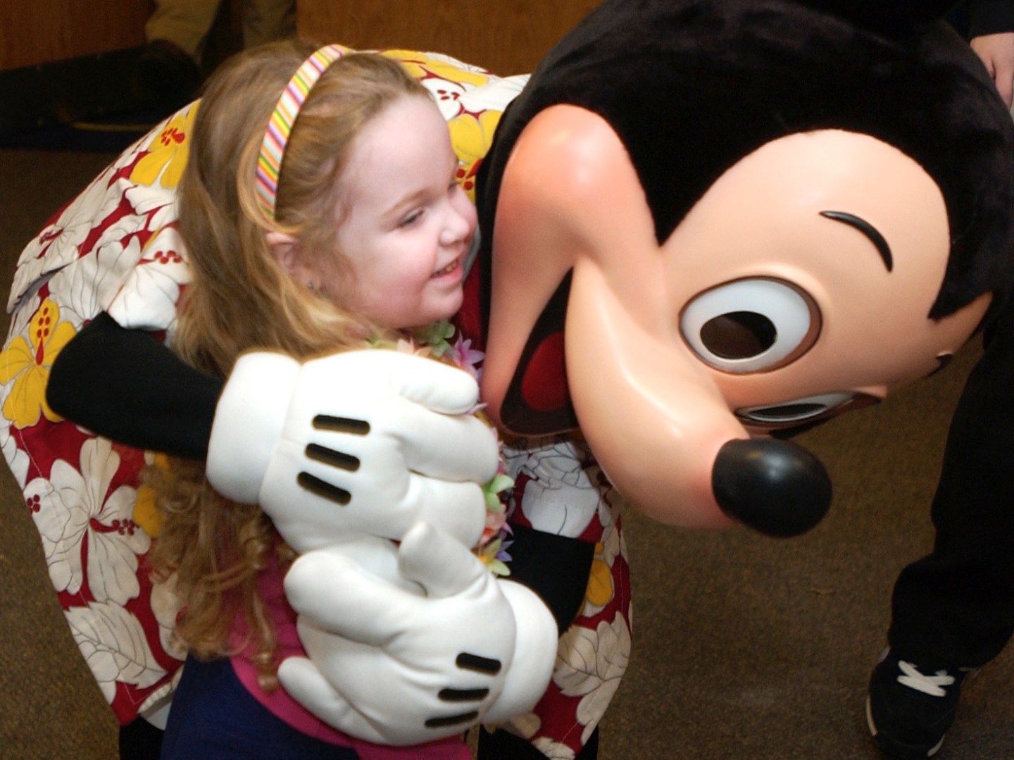 Sarah Hanington, 2, of Wytopitlock, Maine , gets a hug from Mickey Mouse during a special meeting of