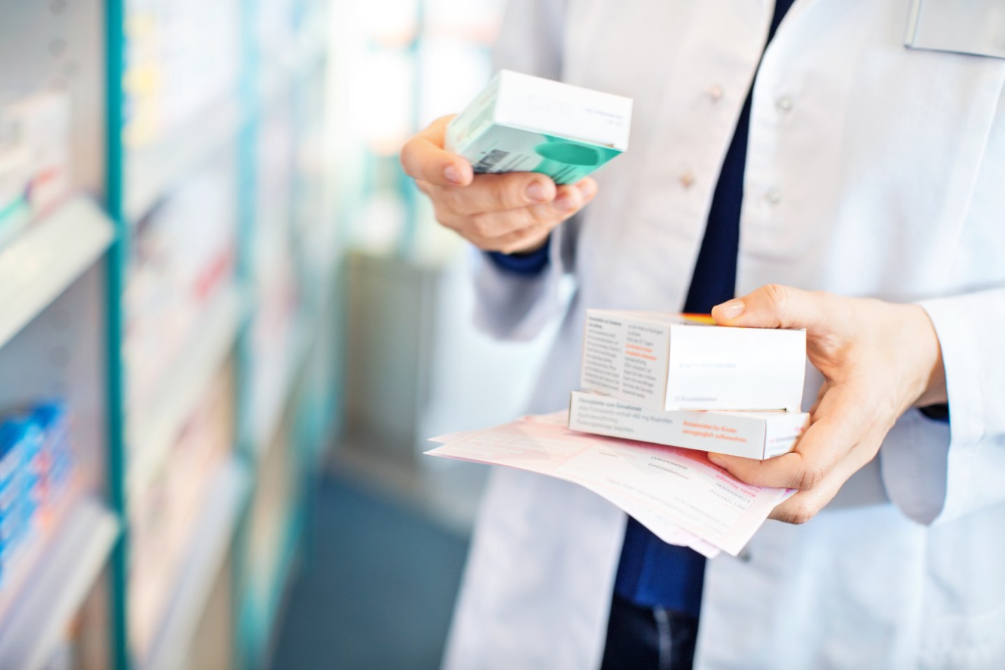 Pharmacist's hands taking medicines from shelf