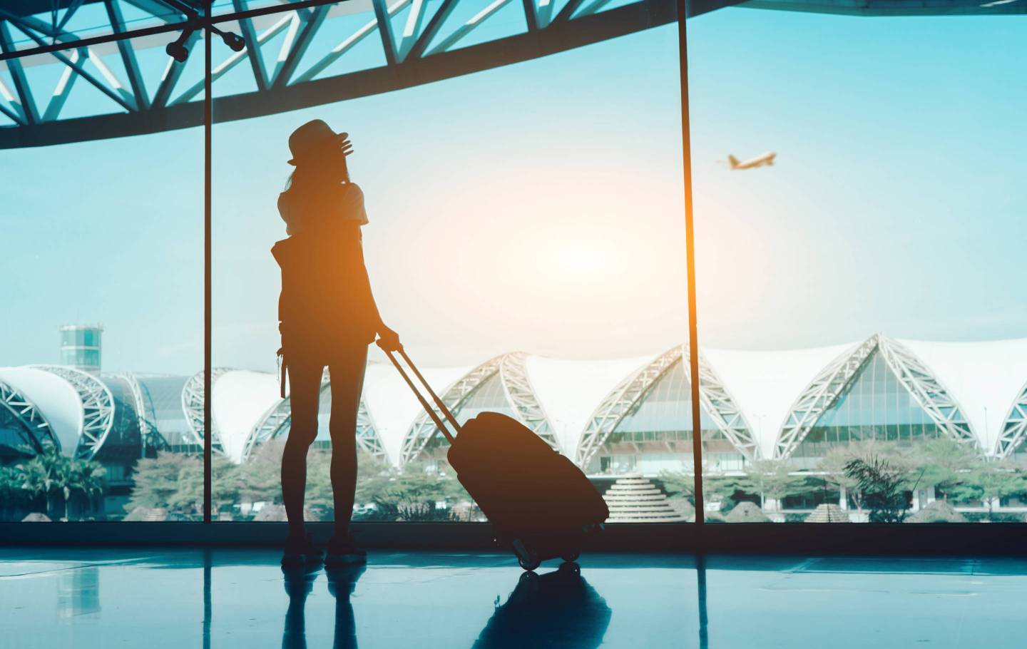 Woman With Luggage Standing In Airport