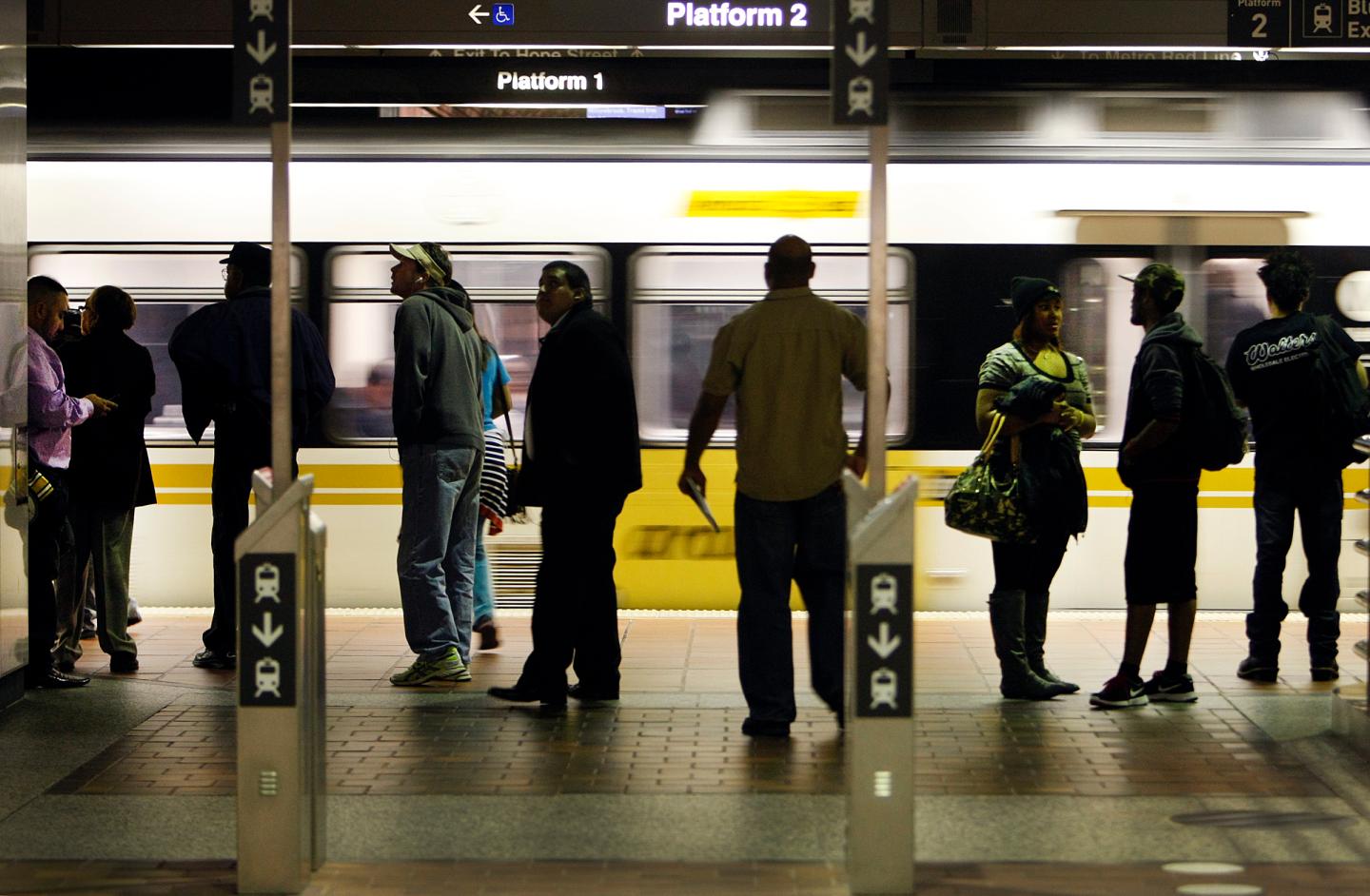 Morning commuters stand past the stand-alone TAP (Transit Access Pass) validators at the transfer p