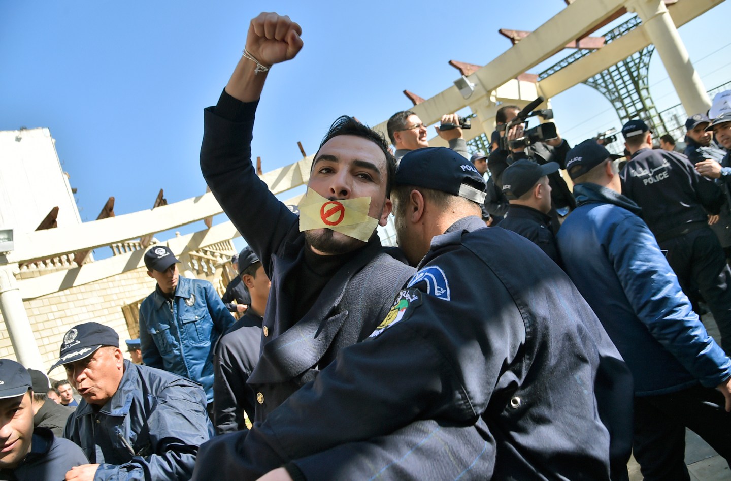 An Algerian policeman restrains a protester participating in a rally organized by journalists against alleged censorship of coverage of protests against a fifth term for veteran President Abdelaziz Bouteflika in Algiers on February 28, 2019.
