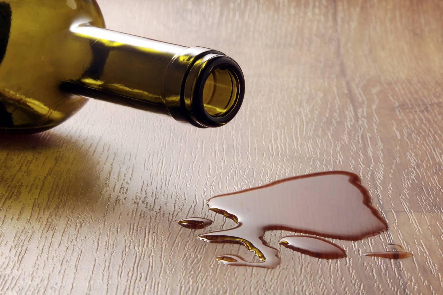 Wine glass and spilled red wine on a durable vinyl flooring with wood effect