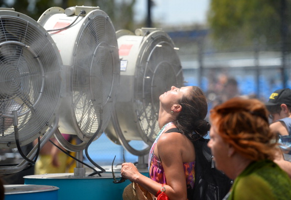 A woman cools off with fans and mist put out for spectators as a heat wave continues to sizzle on day three of the 2014 Australian Open tennis tournament in Melbourne on January 15, 2014. AFP PHOTO / WILLIAM WESTIMAGE RESTRICTED TO EDITORIAL USE - STRICTLY NO COMMERCIAL USE (Photo credit should read WILLIAM WEST/AFP/Getty Images)