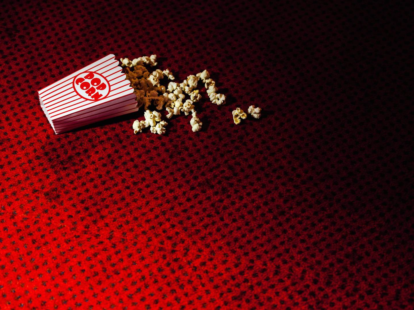 Spilled carton of popcorn on cinema carpet