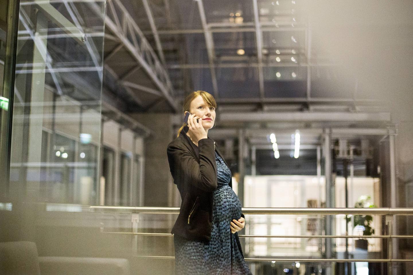 Beautiful pregnant business woman talking on the mobile phone