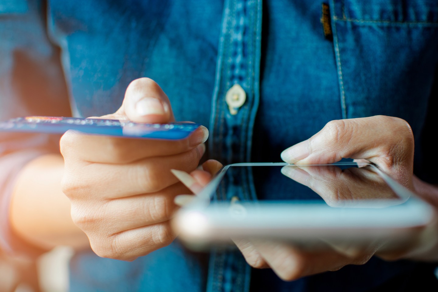 Midsection Of Woman Holding Credit Card While Using Mobile Phone