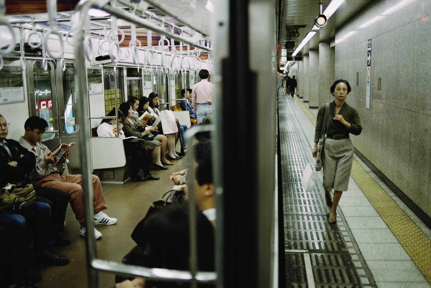 A woman walking through a Tokyo subway station.