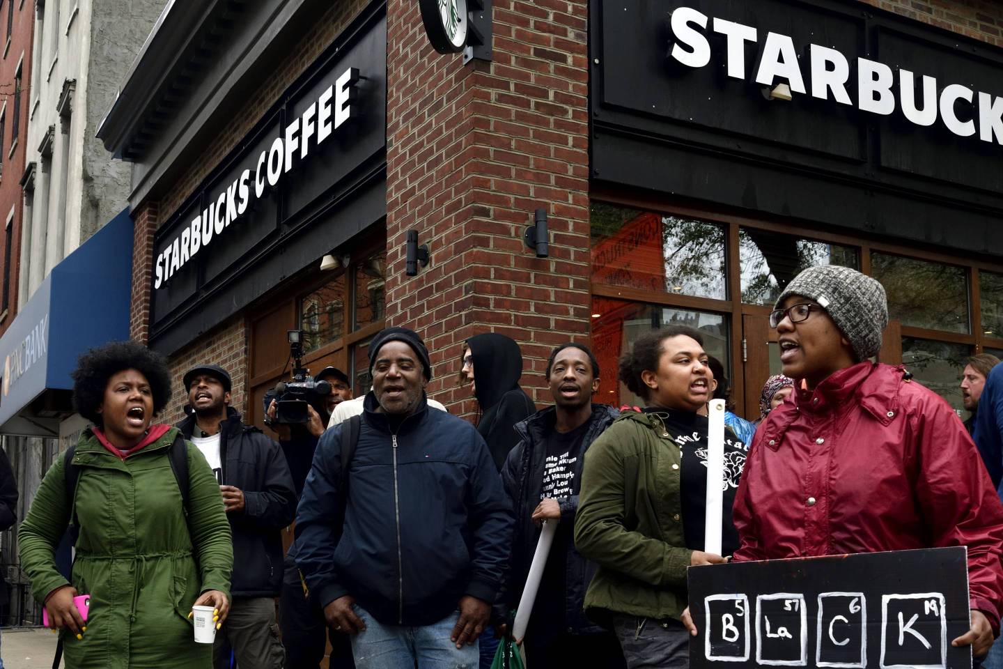 People gather on April 16, 2018 to protest at a Starbucks in Philadelphia, where days earlier two black men were arrested.