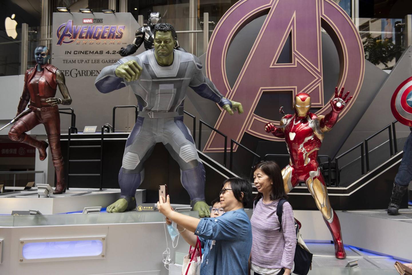 Pedestrians are seen taking a selfie with Marvel and Marvel