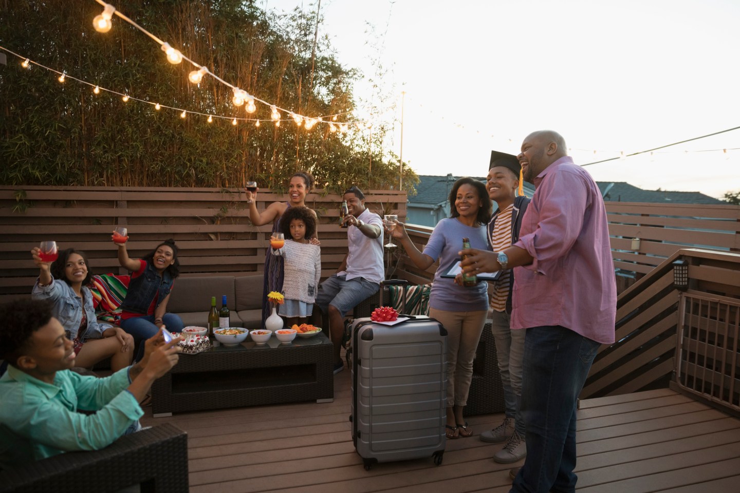 African American family celebrating graduation on summer deck