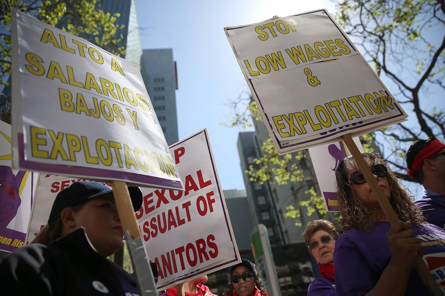 Union workers hold signs during a demonstration in support of a proposal to raise the California minimum wage to $15 by 2022 on March 31, 2016, in Oakland, Calif.