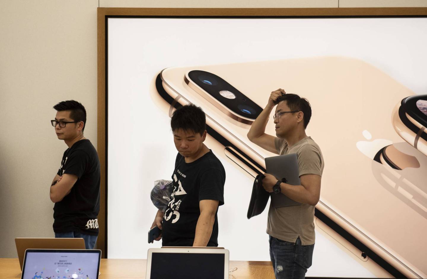 Buyers seen waiting in a queue to purchase Apple products at