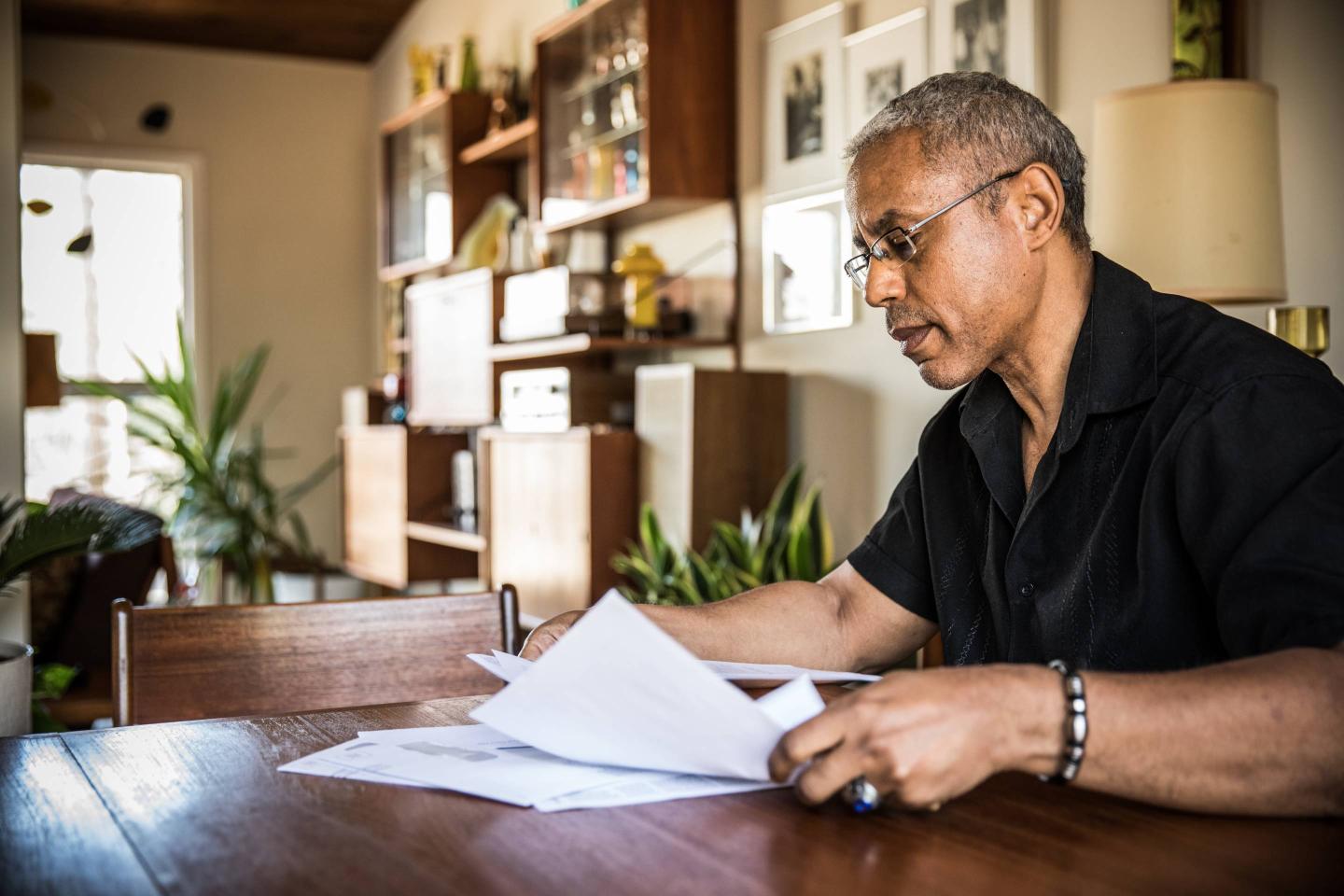 A man pays bills in his home.