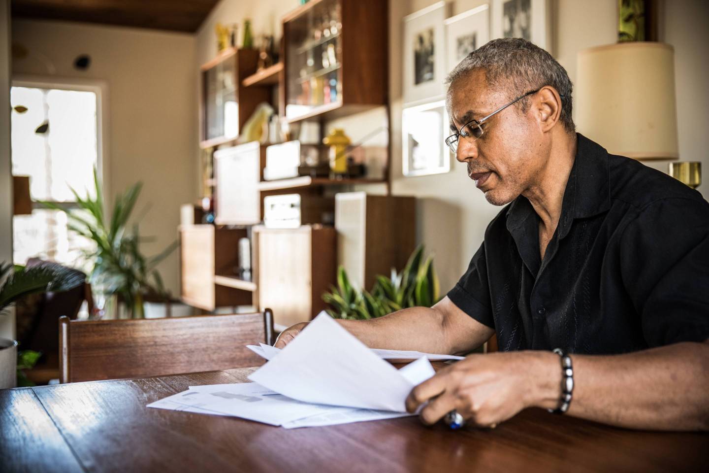 A man pays bills in his home.