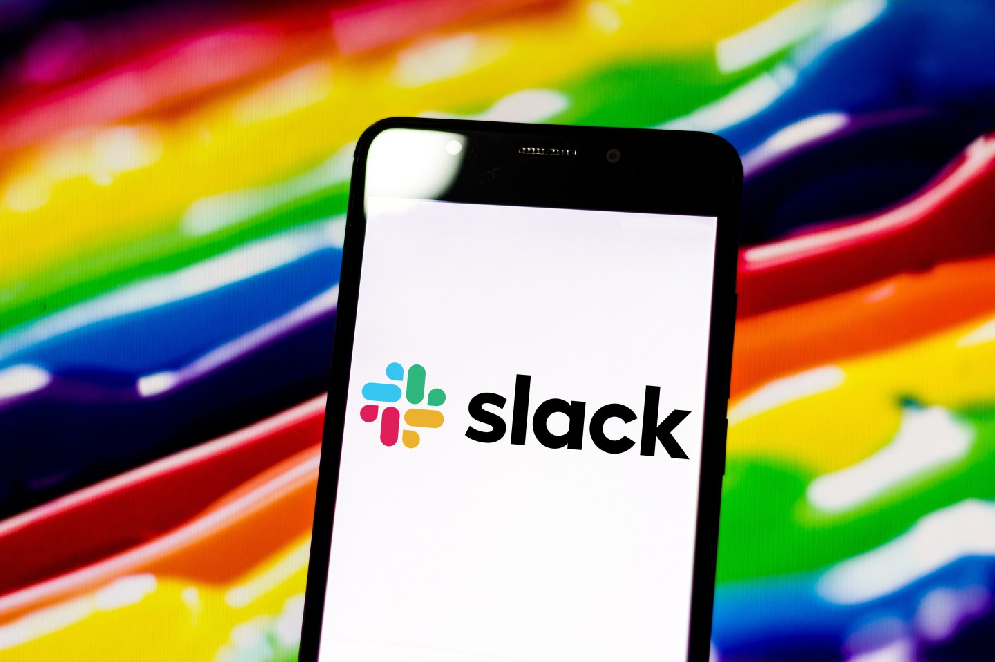 In this photo illustration the Slack logo seen displayed on