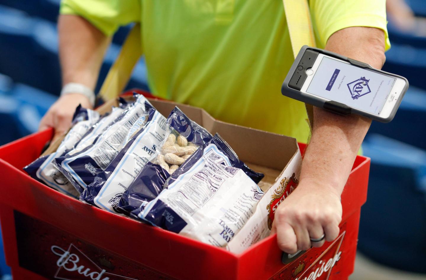 A vendor uses a cashless system to complete a sale during a baseball game at Tropicana Field in Florida.