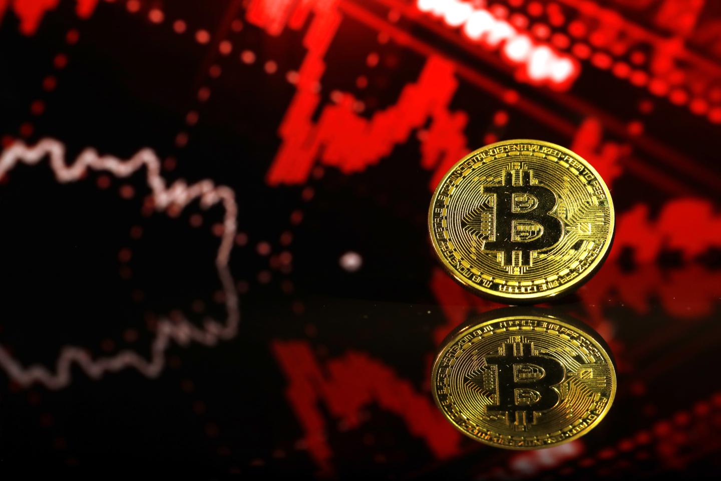 Bitcoin in front of red market graph