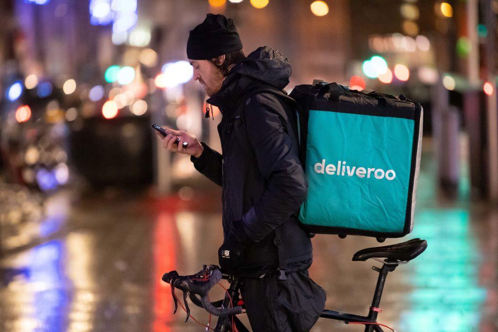 Deliveroo rider checks his phone