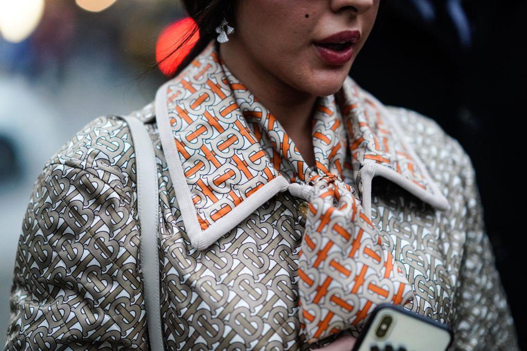 A guest wears a Burberry jacket and monogram scarf, outside Burberry, during London Fashion Week in London in February 2019.