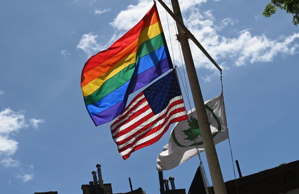 A Rainbow flag and an American flag are seen side by side at the Stonewall National Monument in June
