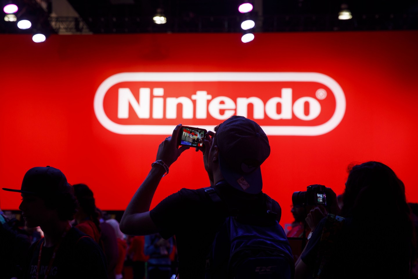 Attendees take photographs while waiting to enter the Nintendo Co. Pokemon Sword and Shield display during the E3 Electronic Entertainment Expo in Los Angeles, California, U.S., on Wednesday, June 12, 2019. For three days, leading-edge companies, groundbreaking new technologies and never-before-seen products are showcased at E3. Photographer: