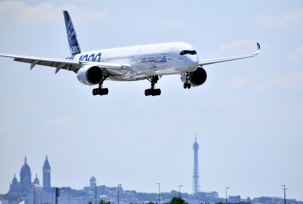 An Airbus A350 XWB is seen above the Paris skyline at the Paris Air Show.