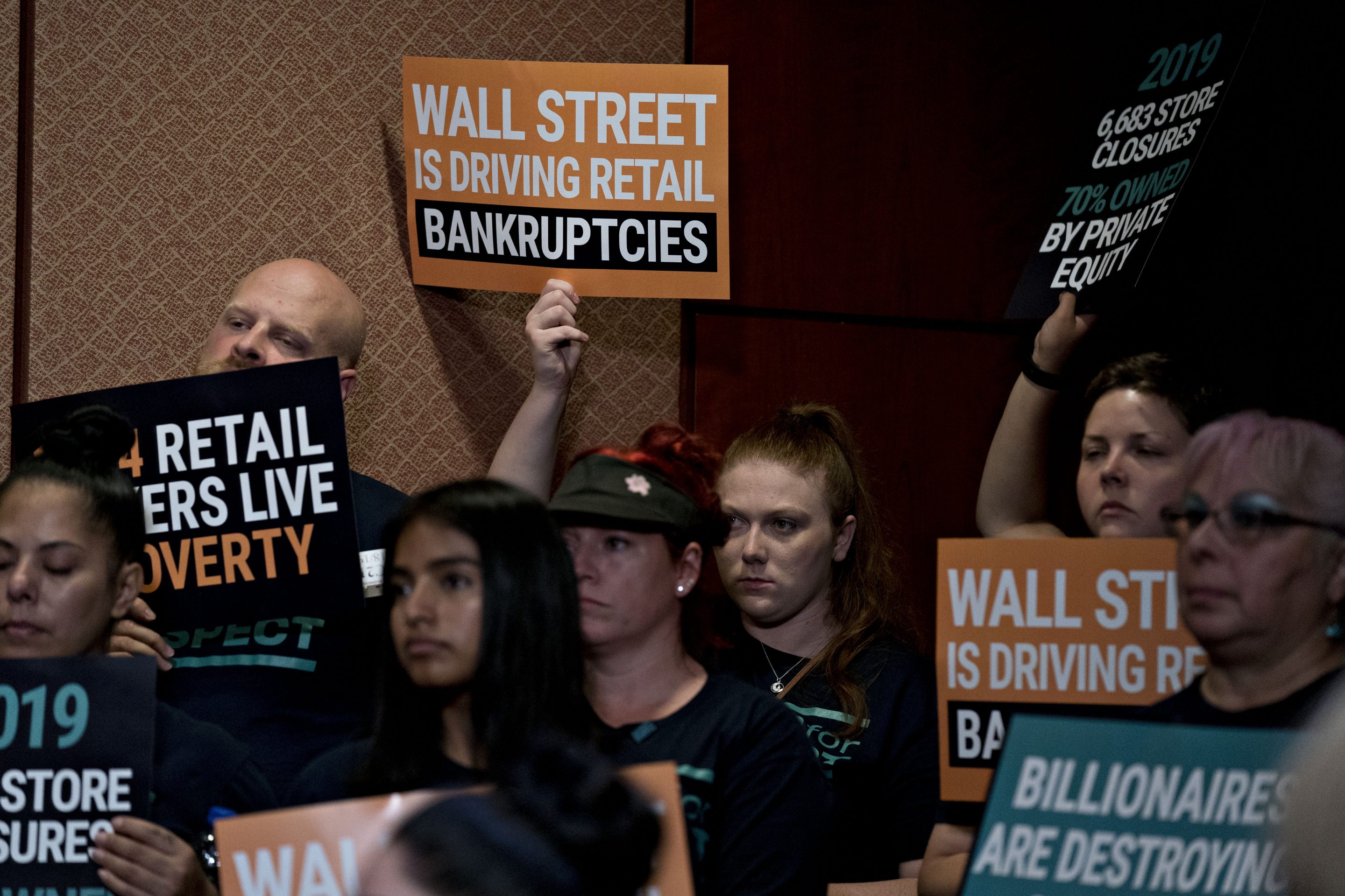 An attendee holds up a sign during a news conference on the Stop Wall Street Looting Act on Capitol Hill in Washington, D.C., on Thursday, July 18, 2019.