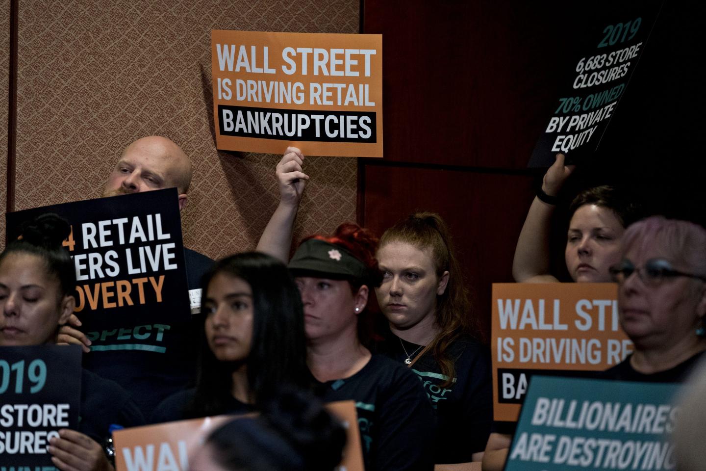 An attendee holds up a sign during a news conference on the Stop Wall Street Looting Act on Capitol Hill in Washington, D.C., on Thursday, July 18, 2019.