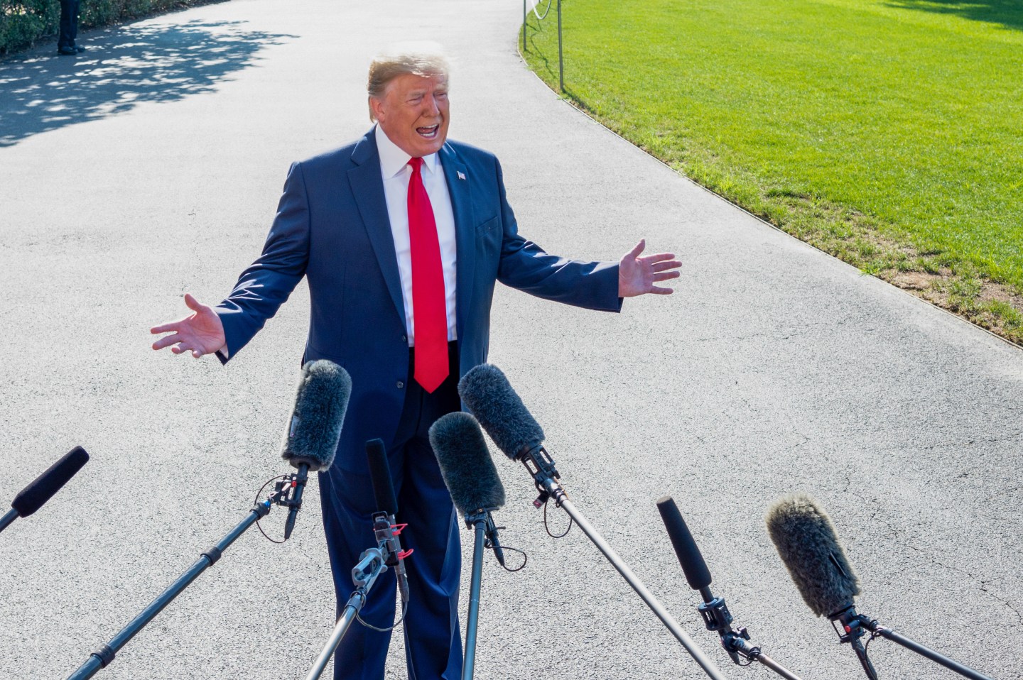 President Donald Trump speaking with the press next to the