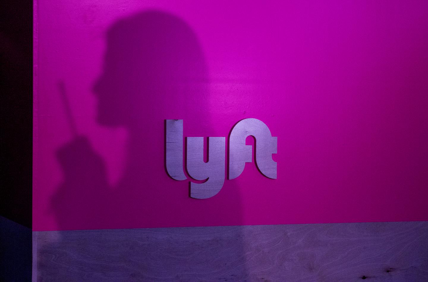 The silhouette of a woman against a Lyft logo