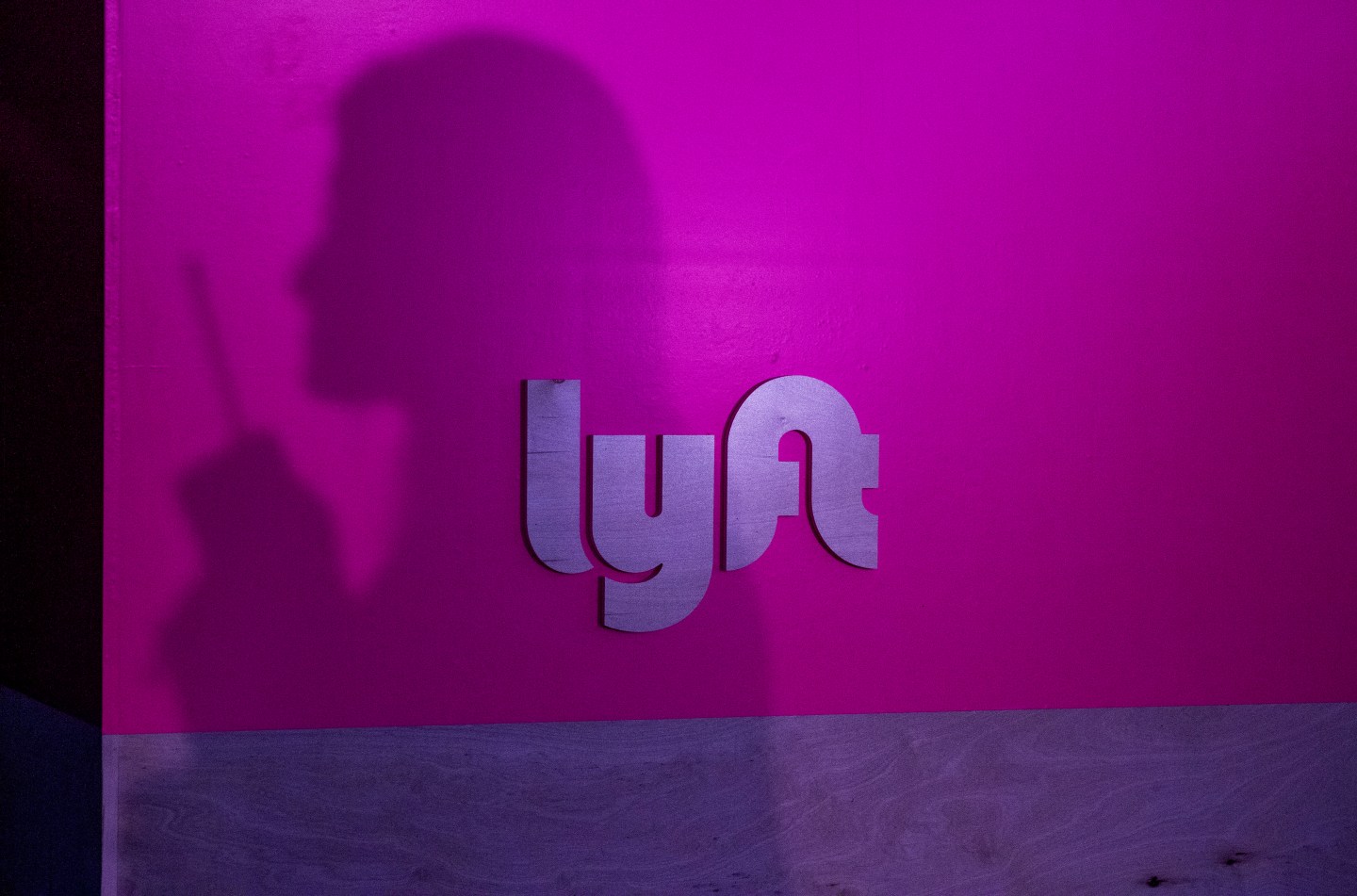 The silhouette of a woman against a Lyft logo