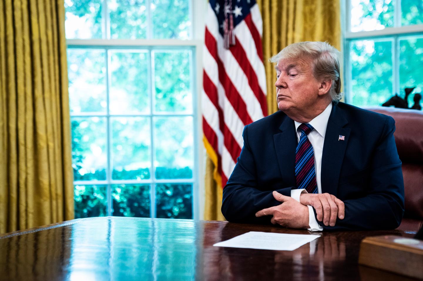 Trump sits at his desk in the Oval Office