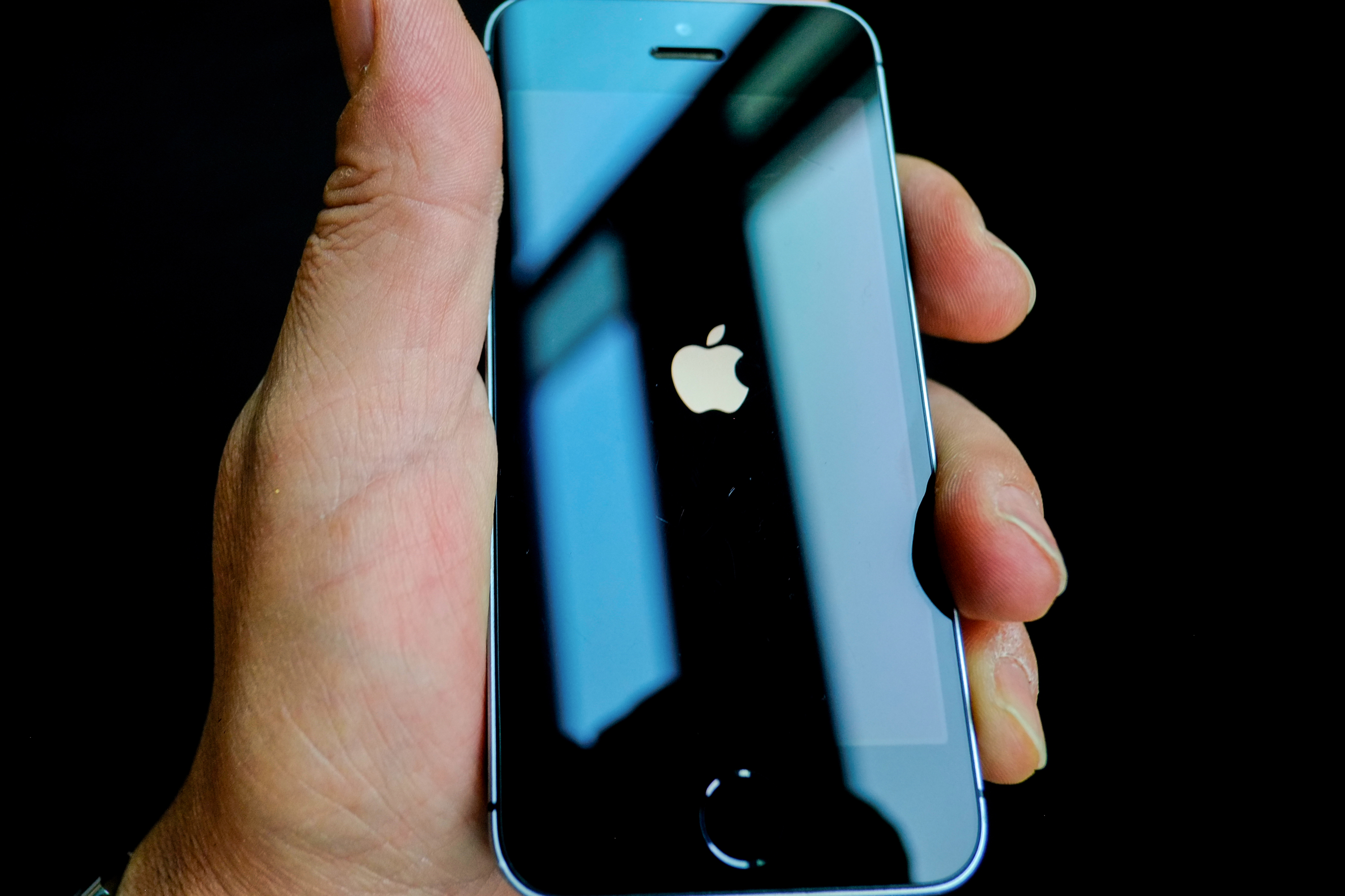 09 August 2019, Berlin: ILLUSTRATION - The Apple logo appears on the monitor when an iPhone SE is booted. Apple offers up to a million dollars in rewards for finding vulnerabilities in its software. This amount is intended to cover particularly serious vulnerabilities through which an attacker could access the core of the operating system without user intervention. For Apple, data security is an important selling point, especially for the iPhone. The Group is investing a great deal of time and effort in this, including a separate data safe in the processor.