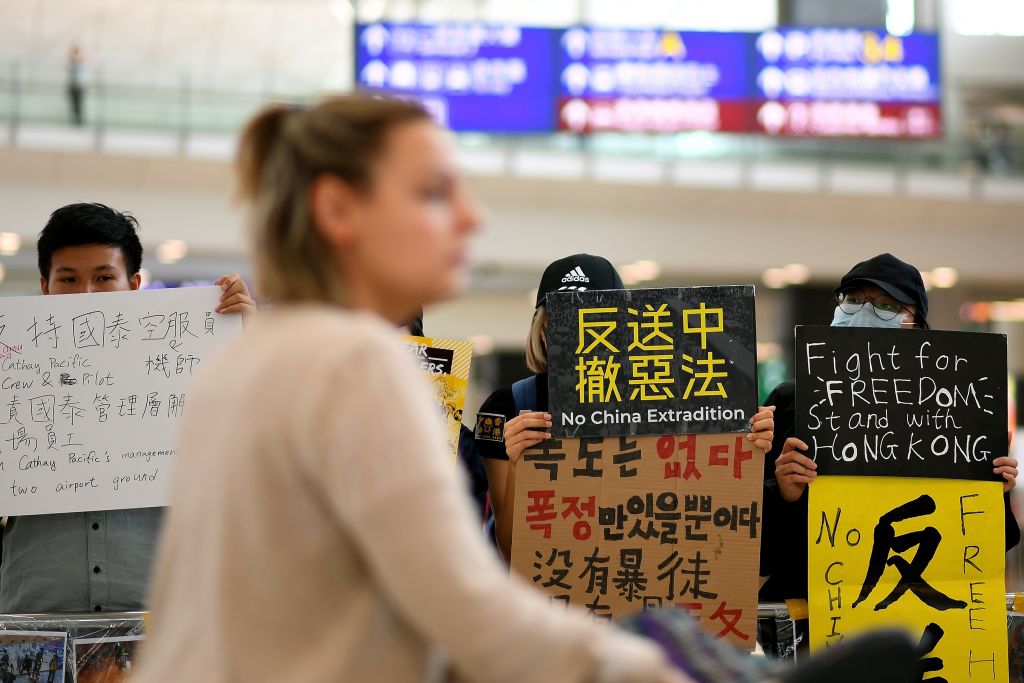 Hong Kong protestors hold signs at airport