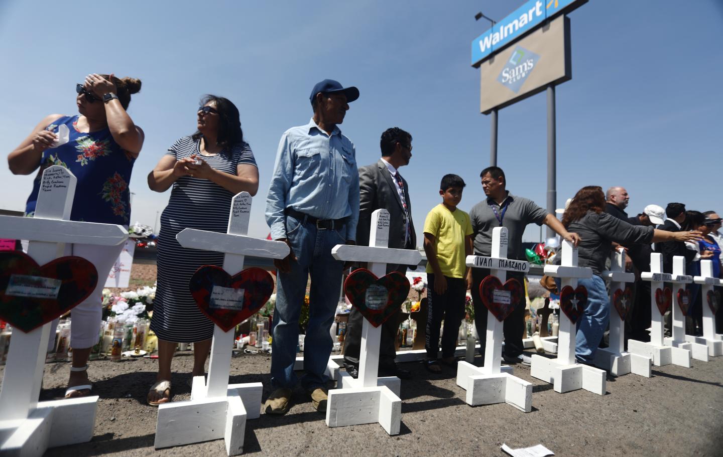 Volunteers stand with handmade crosses memorializing the victims of a mass shooting in El Paso.