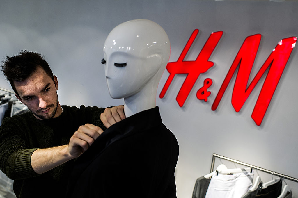 H&M worker arranges store mannequin